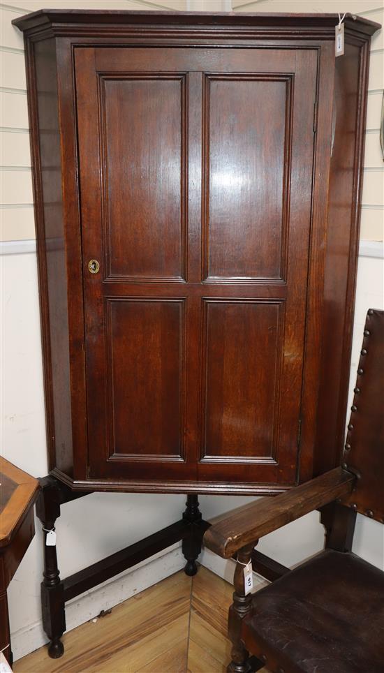 A large 19th century oak corner cupboard on associated stand W.100cm